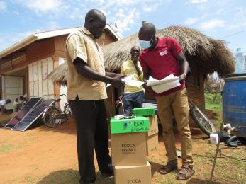 A mercy corps member reviewing a participtants paper work in uganda’s bidi bidi refugee settlement.