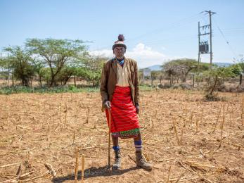 A pastoralist standing in a dry landscape.