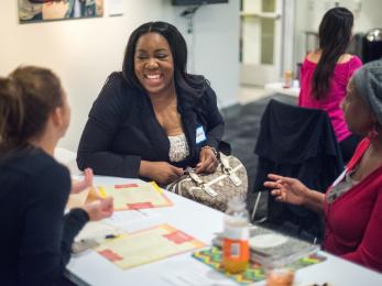 Three women sitting at a table laughing