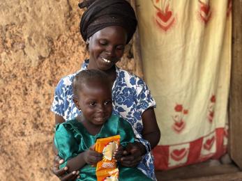 A seated mother holding her small child