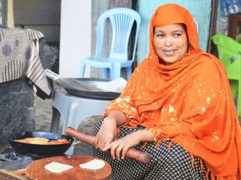 An entrepreneur sitting down and rolling dough.