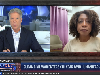 Screenshot of mercy corps ceo with cbs journalist during tv interview..