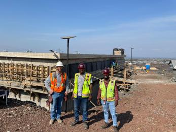 In DRC, three members of the Mercy Corps’ infrastructure team pose together, including engineer Simeon Kakule (center).