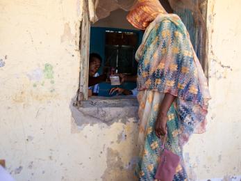 A person handing another cash through a window.