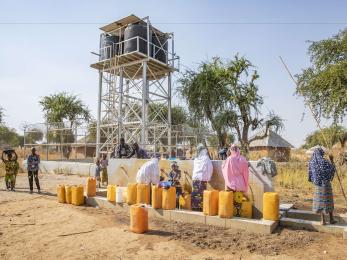 Herders and farmers fill jerrycans from a water point installed by Mercy Corps.