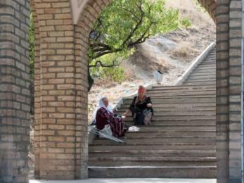 Two people sitting on stairs outside