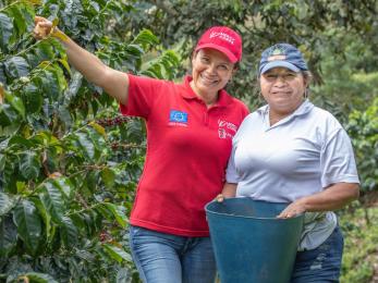 Two people standing together in an orchard.