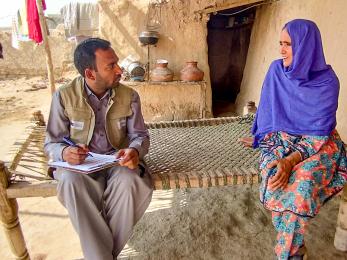 A mercy corps team member listening to someone speaking.