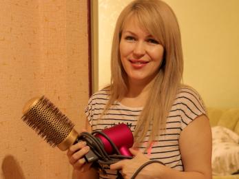 Woman standing with brush and hairdryer