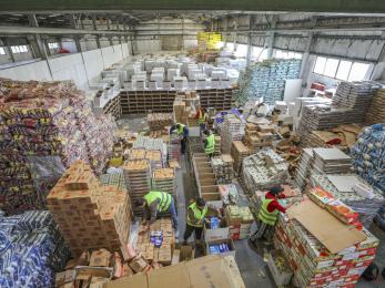 A warehouse with mercy corps staff and volunteers packing 1,300 food kits.