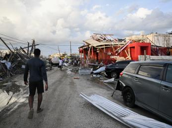 Jamaican walks through street and the Hurricane Melissa destruction.